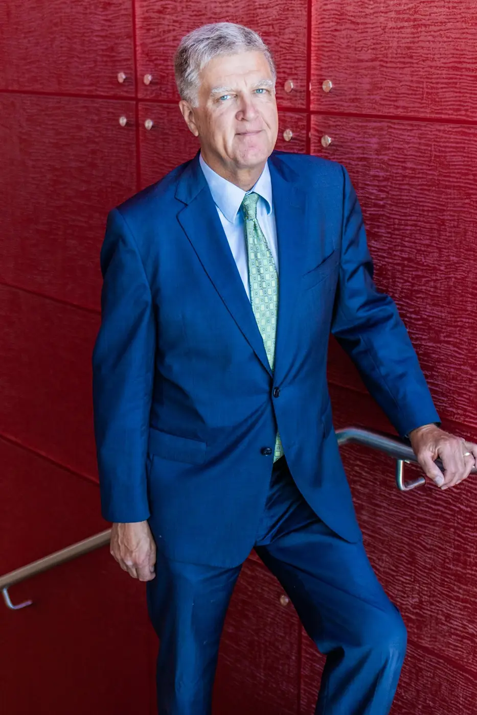 Harald Tomesch in blue suit on staircase